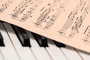 Copertina della recensione raffigurante uno spartito poggiato su un pianoforte