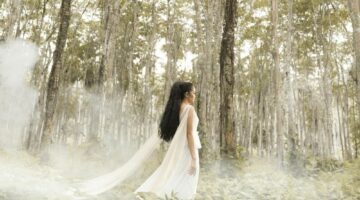 bosco evanescente e figura femminile vestita di bianco