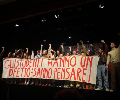 Il cast è in scena esibendo uno striscione di protesta