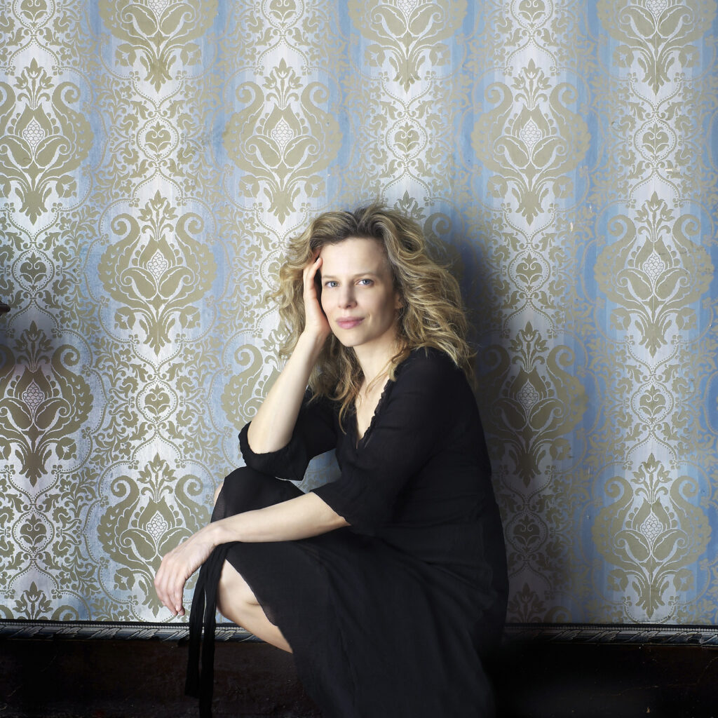 Sonia Bergamasco - l'attrice è inginocchiata. Il volto è rivolto verso di noi e ha un'espressione pacata. Il braccio sinistro poggia sulla gamba sinistra; il gomito destro poggia sul ginocchio destro e la mano destra poggia delicatamente sul lato destro del volto.